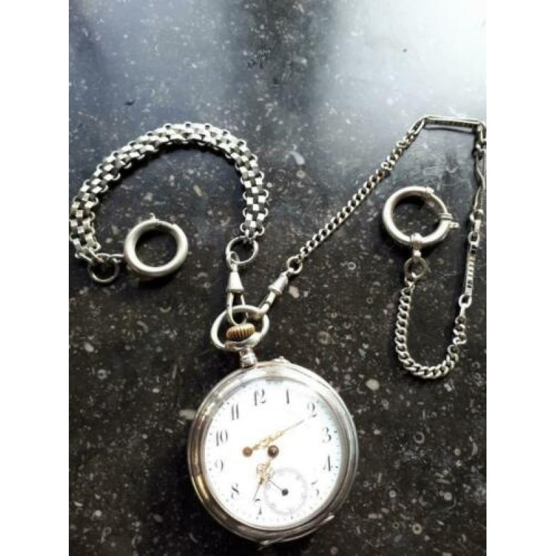 Remontoir Zakhorloge zilver met 2 kettingen.