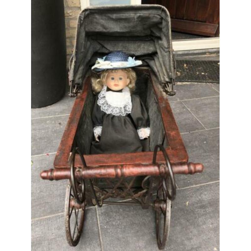 Antieke poppenwagen met pop