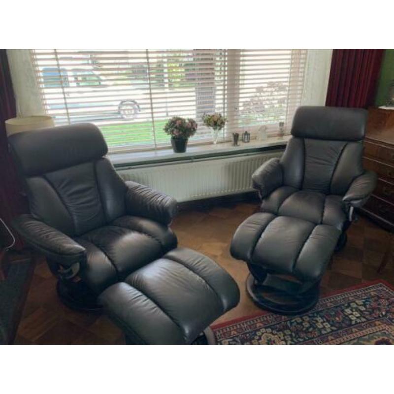 2 relax leren fauteuils met voeten bank
